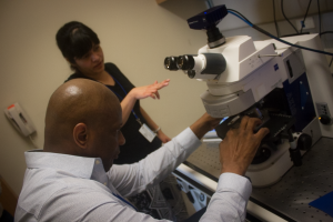 Freelance health writer and producer Rod McCullom learns how to mount a sample underneath a microscope.